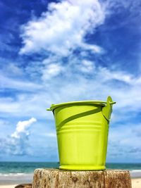 The bucket is placed on wood, the back is a beautiful sea and sky.