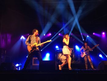 People playing guitar at music concert