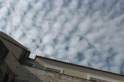 Low angle view of building against cloudy sky