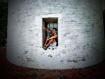 Portrait of woman sitting on wall