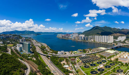 High angle view of city by sea against sky