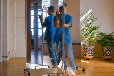 Rear view of man standing at home