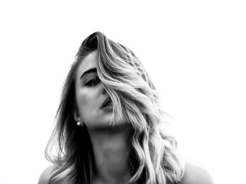 Close-up of young woman against white background