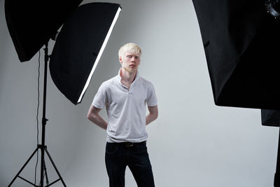 Portrait of man photographing against gray background