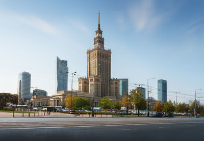 Buildings by river against sky