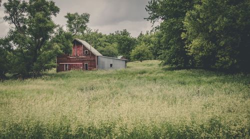 Abandoned house on field against sky