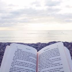 Close-up of text on beach against sky