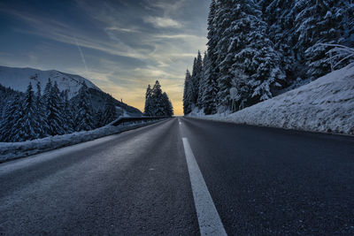 Empty road along snow covered landscape