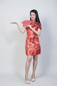 Portrait of a smiling young woman against white background