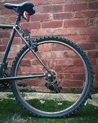 Bicycle wheel against brick wall