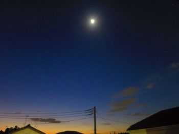 Low angle view of silhouette electricity pylon against sky at night