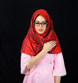 Full length of woman standing against black background