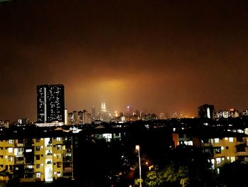 Illuminated buildings in city against sky at night