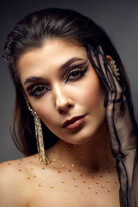 Close-up portrait of young woman against black background