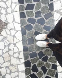 Low section of person standing on tiled floor