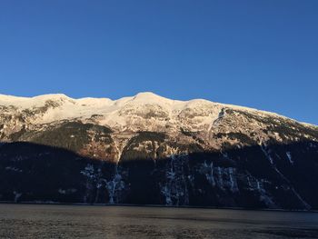 Scenic view of snowcapped mountains against clear blue sky