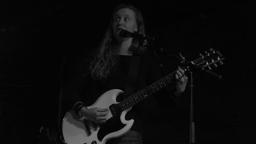 Man holding guitar over black background