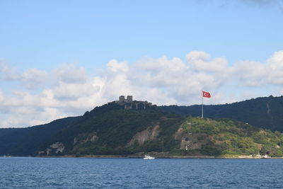 Scenic view of sea and mountains against sky