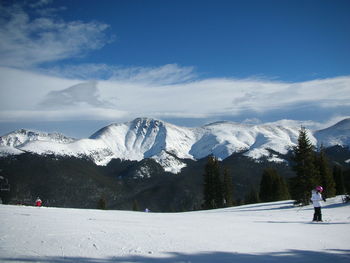 People skiing on snowcapped mountain against sky