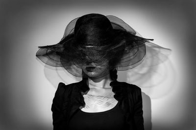 Portrait of woman standing against gray background