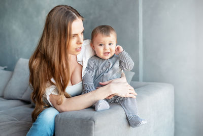 Mother and daughter sitting on floor