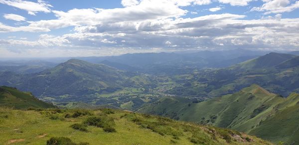 Scenic view of valley and mountains against sky