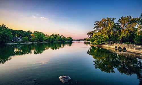 Scenic view of lake against sky at sunset