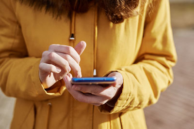 Midsection of man using mobile phone