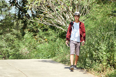 Portrait of man walking on footpath
