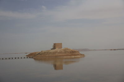 Built structure in sea against sky
