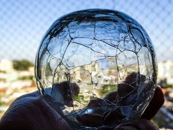 Close-up of cropped hand holding wet crystal ball