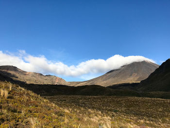 Scenic view of mountains against blue sky