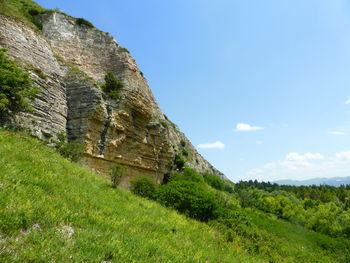 Low angle view of rocky mountain against sky