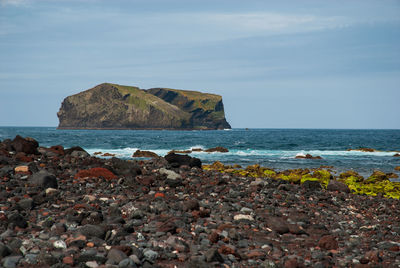 Rocks on beach against sky