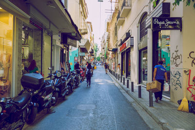 People on street amidst buildings in city