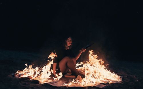 Young woman sitting on bonfire