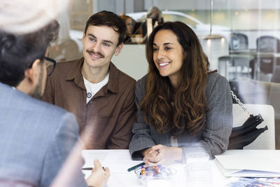 Happy couple meeting with real estate agent at desk in office