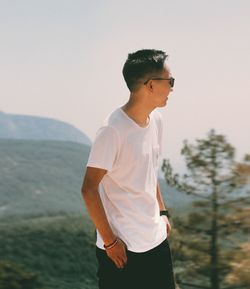 Man standing on mountain against sky during sunny day