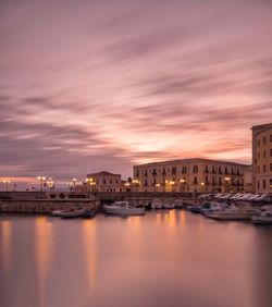 Reflection of illuminated buildings in canal at sunset