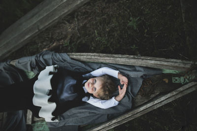 High angle portrait of girl lying in abandoned boat