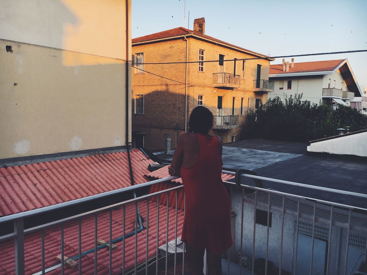 REAR VIEW OF MAN STANDING ON HOUSE