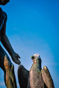 Low angle view of birds against blue sky