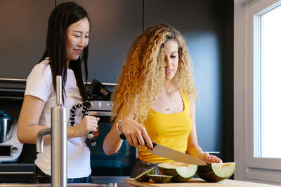 Young woman standing by food at home