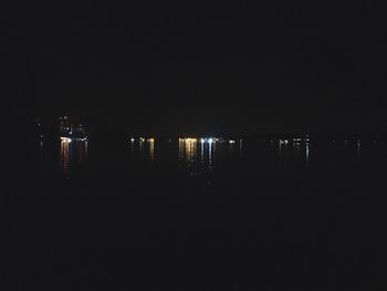 Illuminated city against sky at night