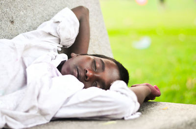 Boy sleeping on bench at park