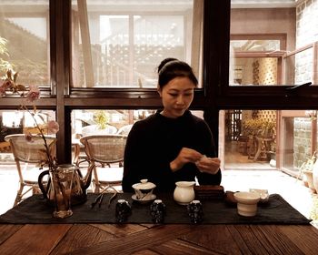 Woman sitting by table in restaurant