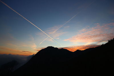 Low angle view of vapor trails in sky at night