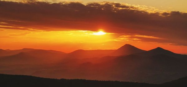 Scenic view of silhouette mountains against sky during sunset