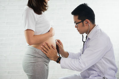 Doctor examining pregnant woman in hospital
