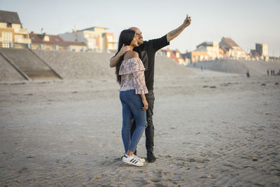 Full length of young woman standing on beach